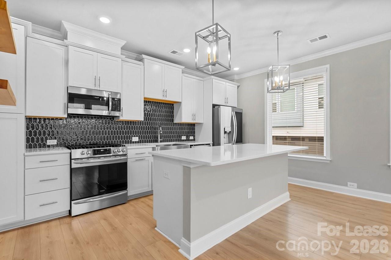 1515 Hidden Falls Road Charlotte, NC 28206 - Photo 12 of 35 a kitchen with stainless steel appliances granite countertop a sink a stove a refrigerator cabinets and a window