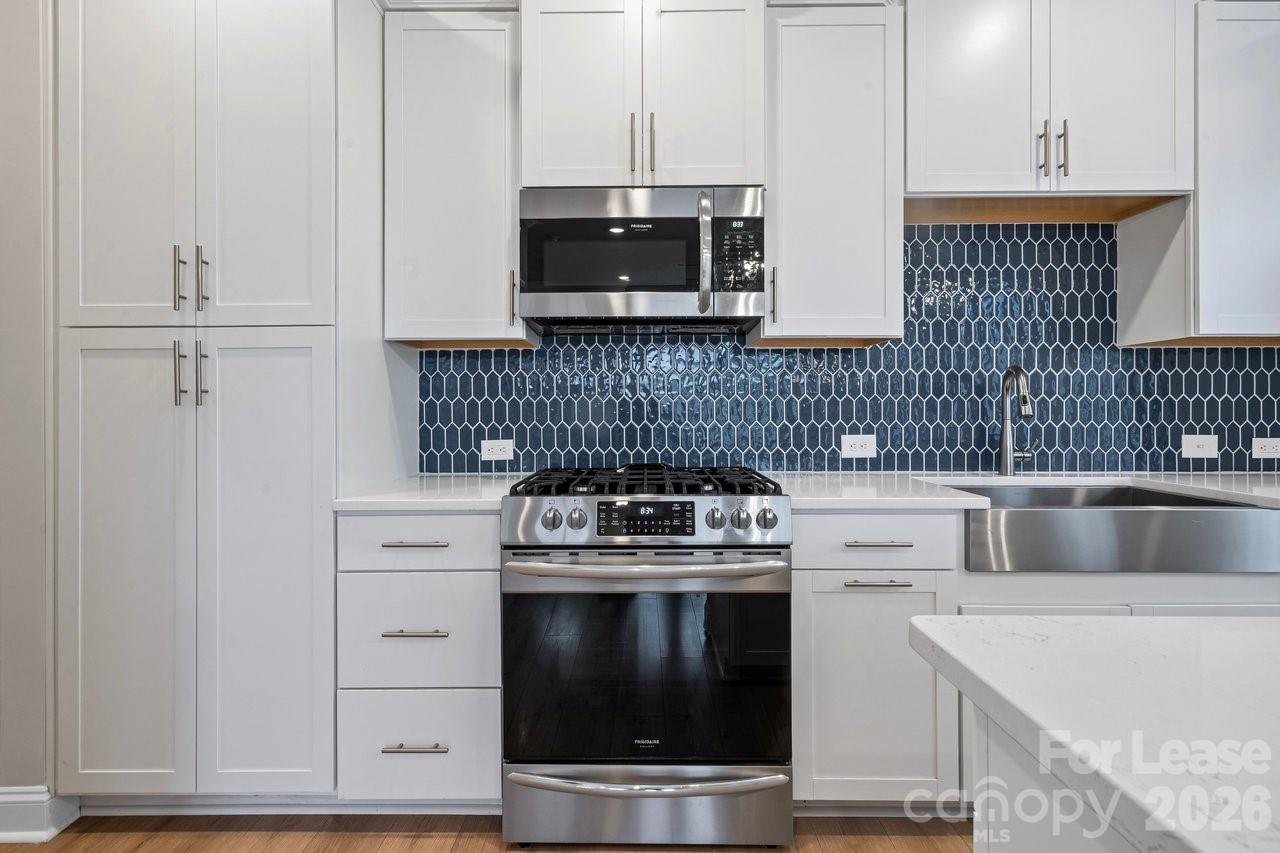 1515 Hidden Falls Road Charlotte, NC 28206 - Photo 14 of 35 a kitchen with granite countertop white cabinets and stainless steel appliances