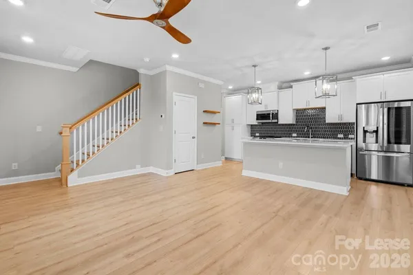 a view of kitchen with wooden floor and electronic appliances