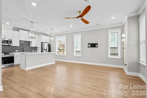 a large kitchen with stainless steel appliances granite countertop a refrigerator and a stove top oven