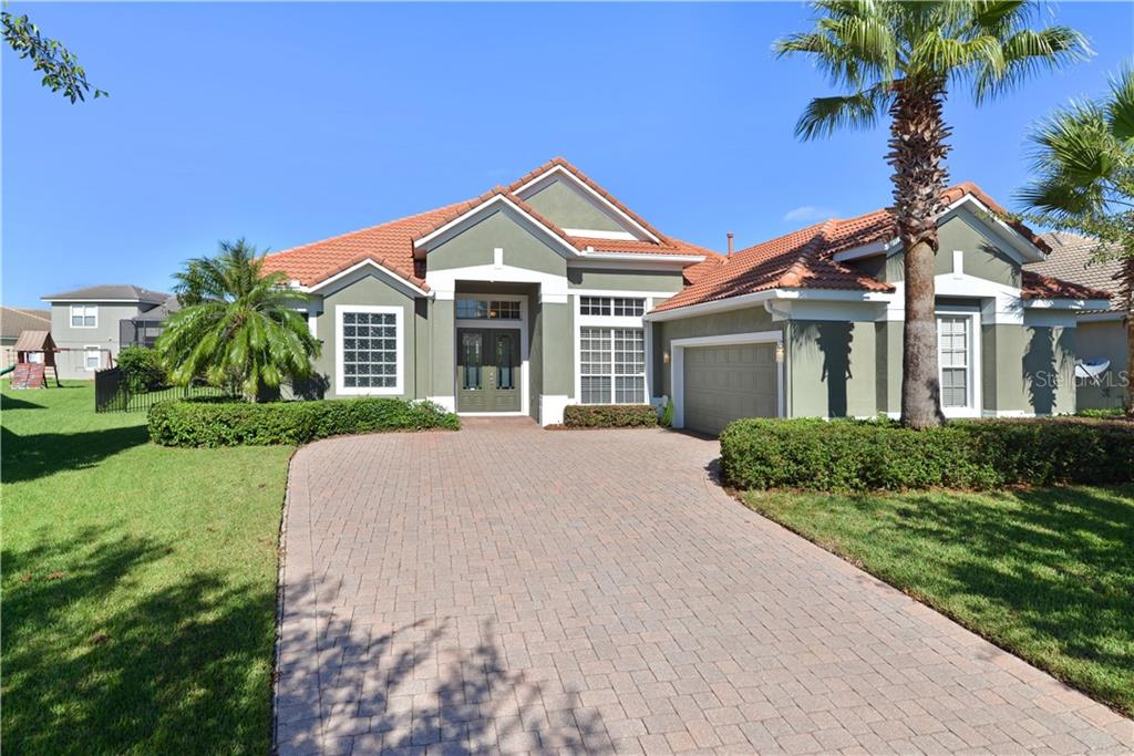 a front view of a house with a yard and potted plants
