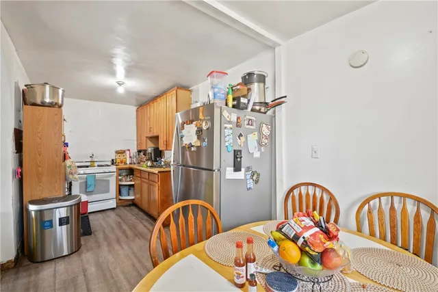 a kitchen with stainless steel appliances granite countertop a refrigerator a stove top oven a sink dishwasher and wooden floor