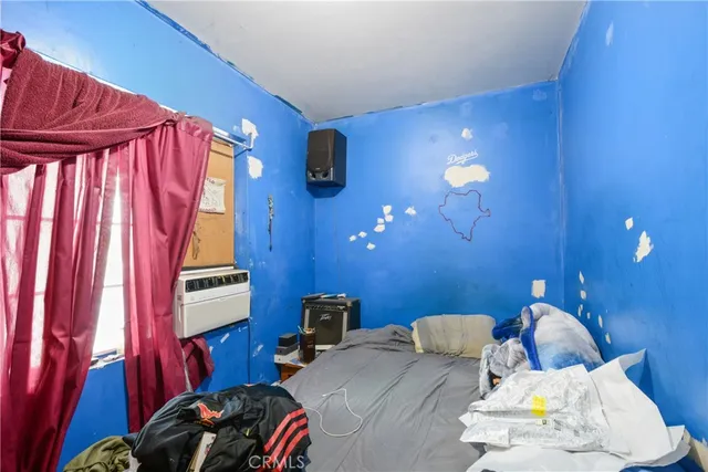 a bedroom with bed and a chair