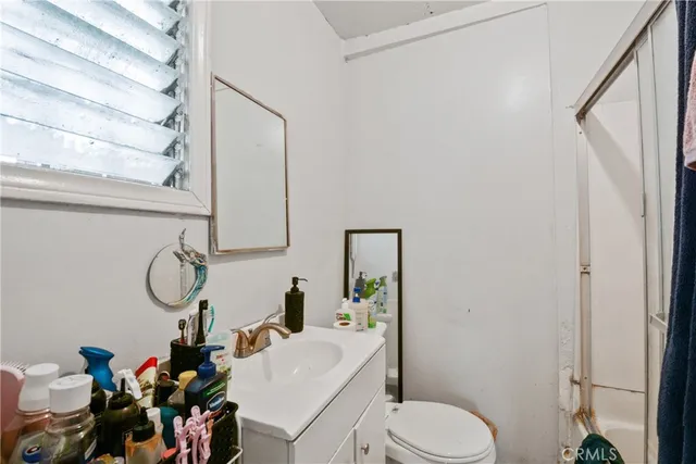 a bathroom with a toilet sink vanity mirror and tub