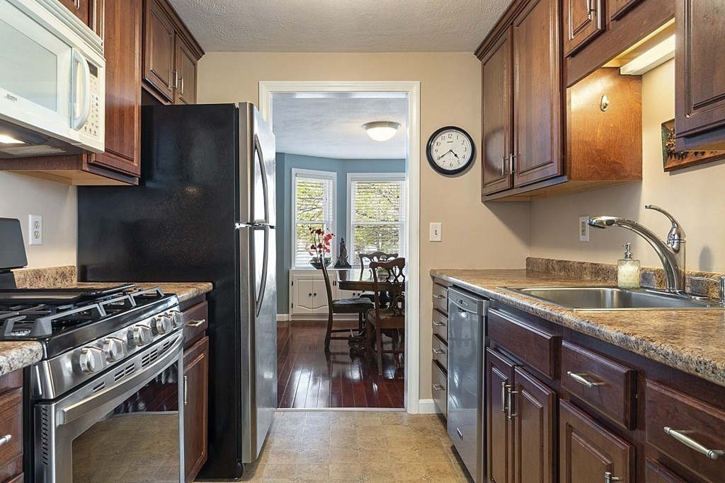 1541 Middlesex Street, Unit 16 Lowell, MA 01851 - Photo 6 of 29 a kitchen with granite countertop a stove and a refrigerator