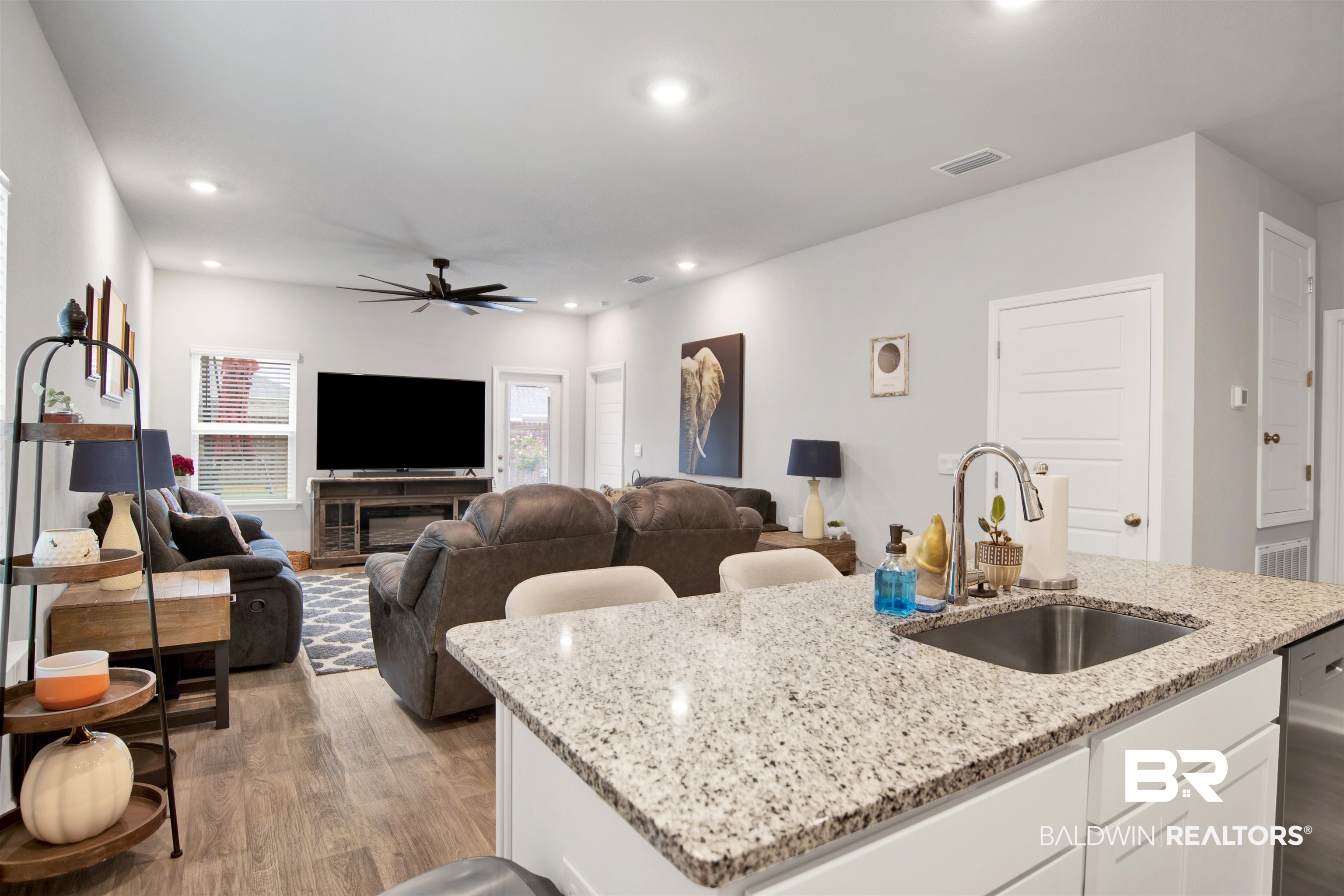 12813 Patriot Way Daphne, AL 36527 - Photo 6 of 23 Kitchen island featuring a stainless steel sink, chrome faucet, and a light-toned granite countertop