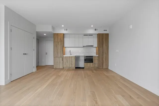 a view of a kitchen with refrigerator and white cabinets