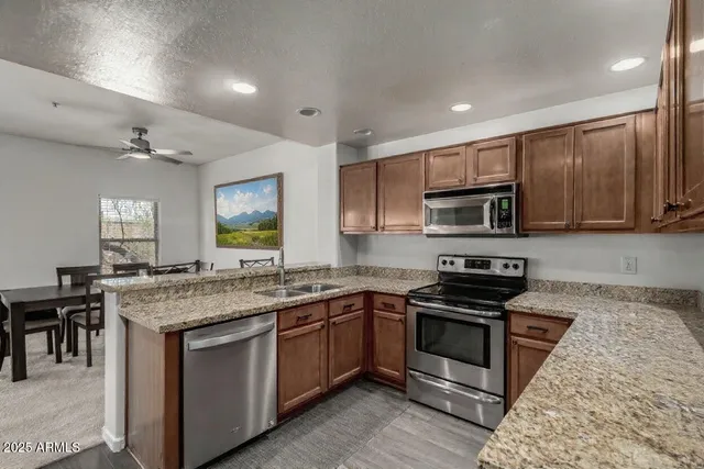 a kitchen with granite countertop stainless steel appliances and wooden cabinets