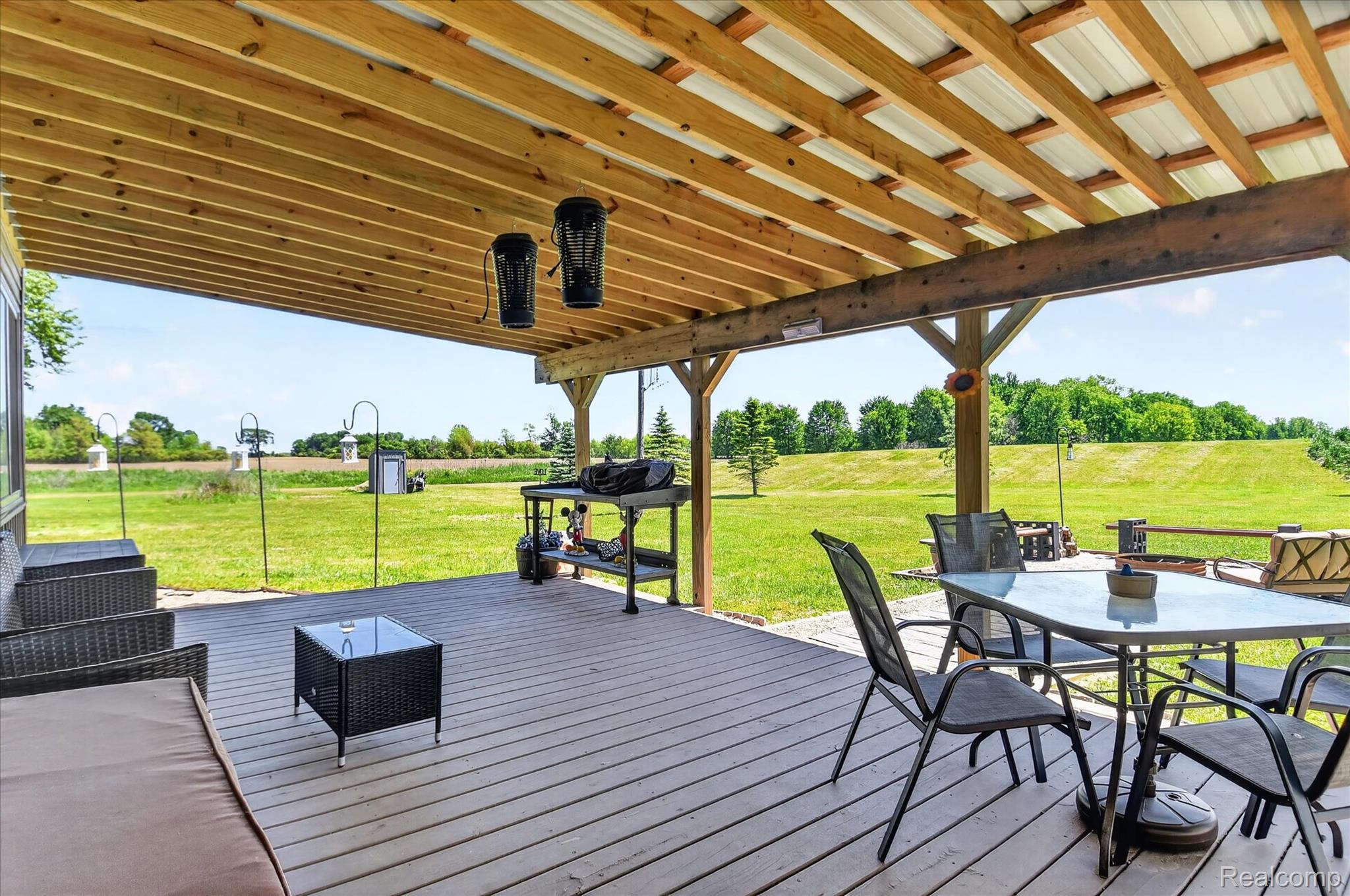 3949 West Burns Line Road Brown City, MI 48416 - Photo 61 of 70 Expansive covered patio featuring a wood-finish ceiling, exposed beams, and a composite deck surface