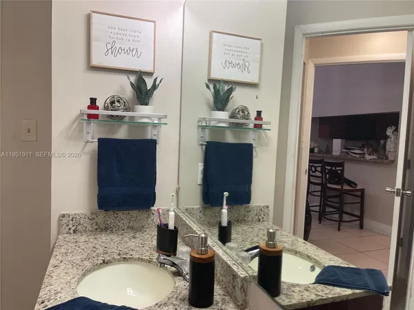 a bathroom with a granite countertop shower and a sink
