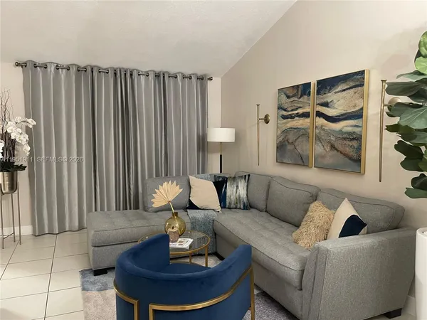 a living room with furniture and a potted plant