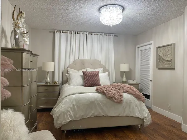 a bedroom with a bed and a chandelier