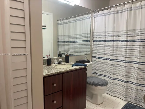 a bathroom with a granite countertop sink toilet and shower