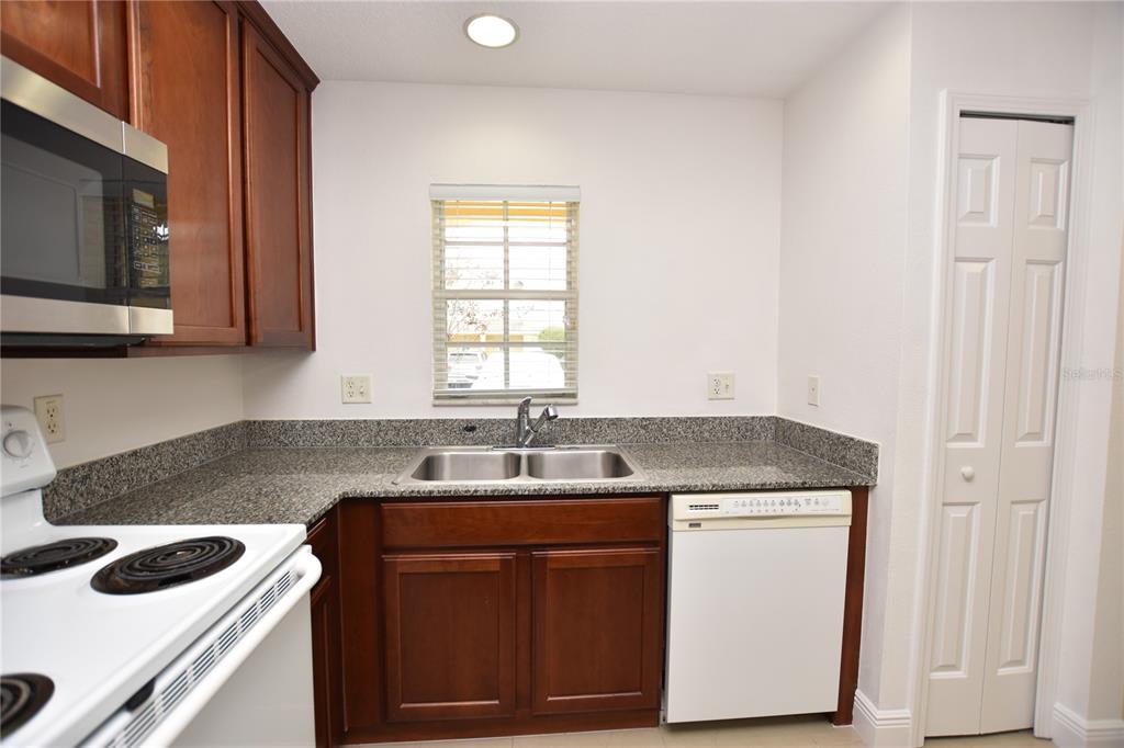 5410 River Rock Road Lakeland, FL 33809 - Photo 4 of 26 a kitchen with granite countertop cabinets stainless steel appliances a sink and a window