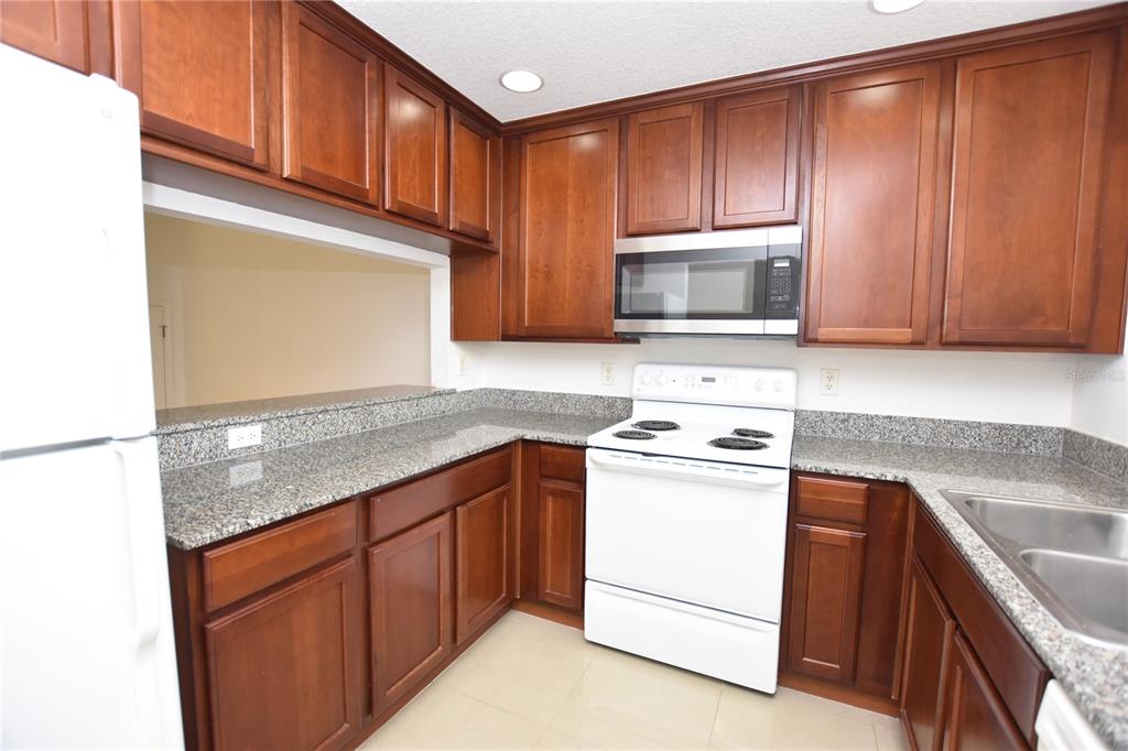 5410 River Rock Road Lakeland, FL 33809 - Photo 5 of 26 a kitchen with stainless steel appliances granite countertop wooden cabinets a sink and a stove