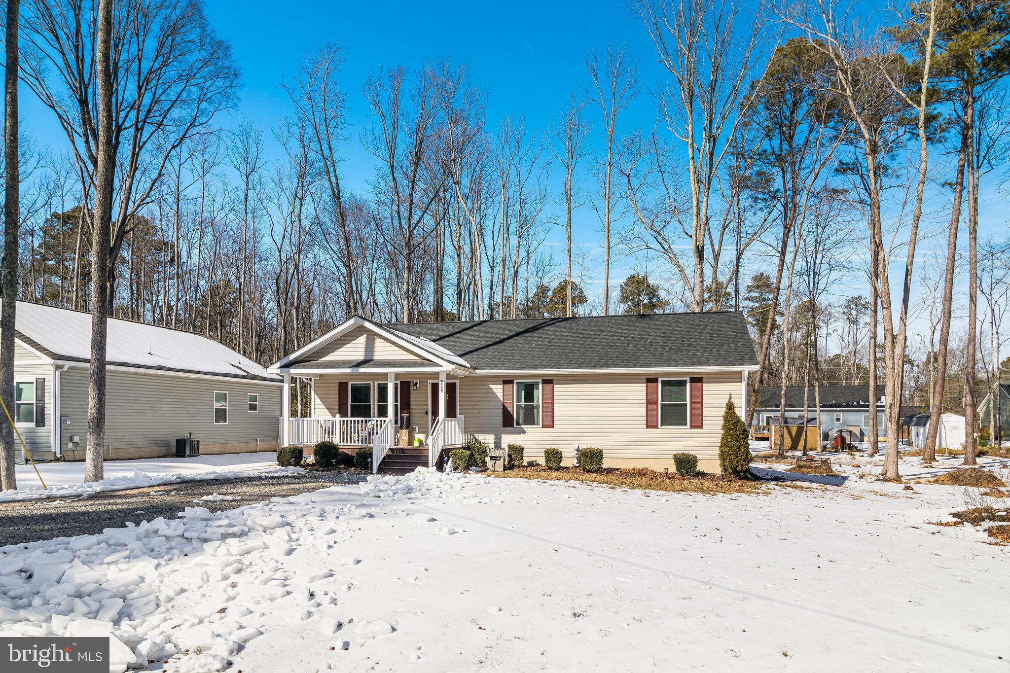 339 Azure Drive Colonial Beach, VA 22443 - Photo 1 of 28 a front view of a house with a yard covered with snow and trees