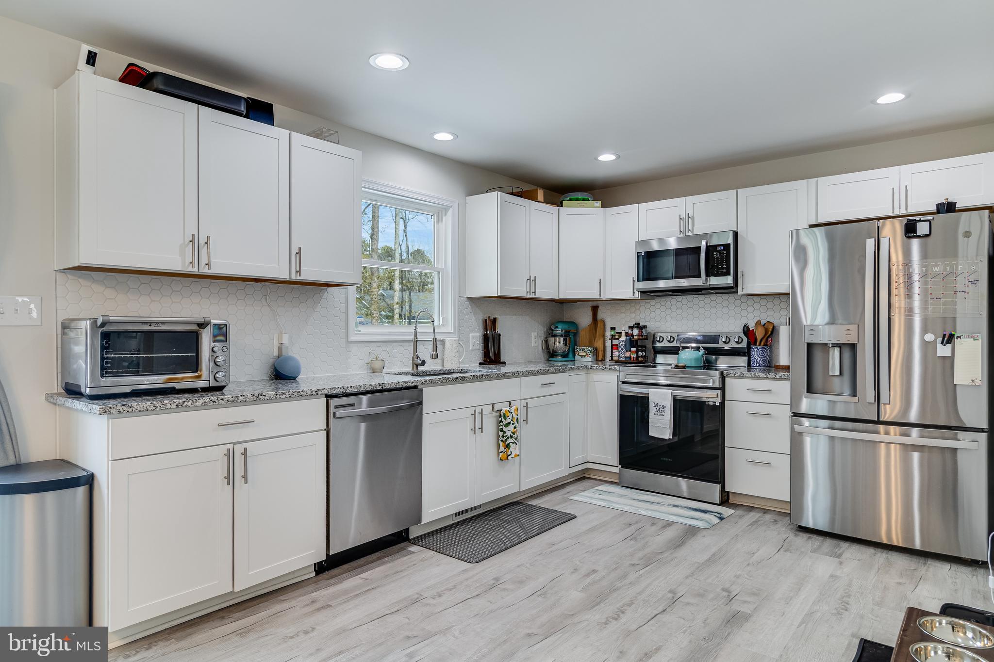 339 Azure Drive Colonial Beach, VA 22443 - Photo 9 of 28 a kitchen with white cabinets and stainless steel appliances