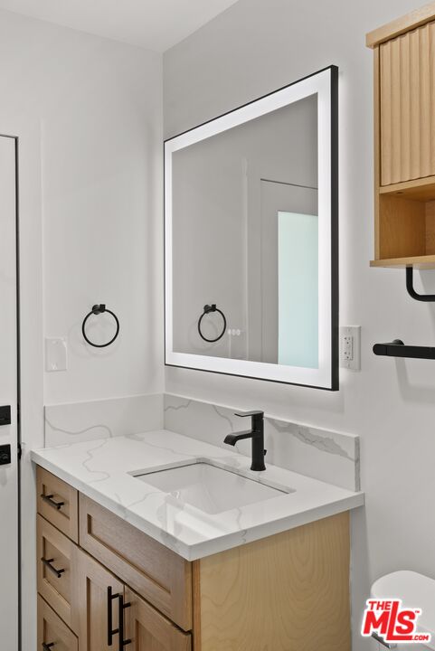 4020 La Salle Avenue Culver City, CA 90232 - Photo 26 of 33 a bathroom with a granite countertop sink a mirror and a vanity
