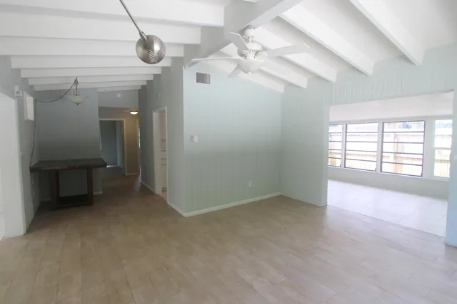 en empty room with windows and ceiling fan