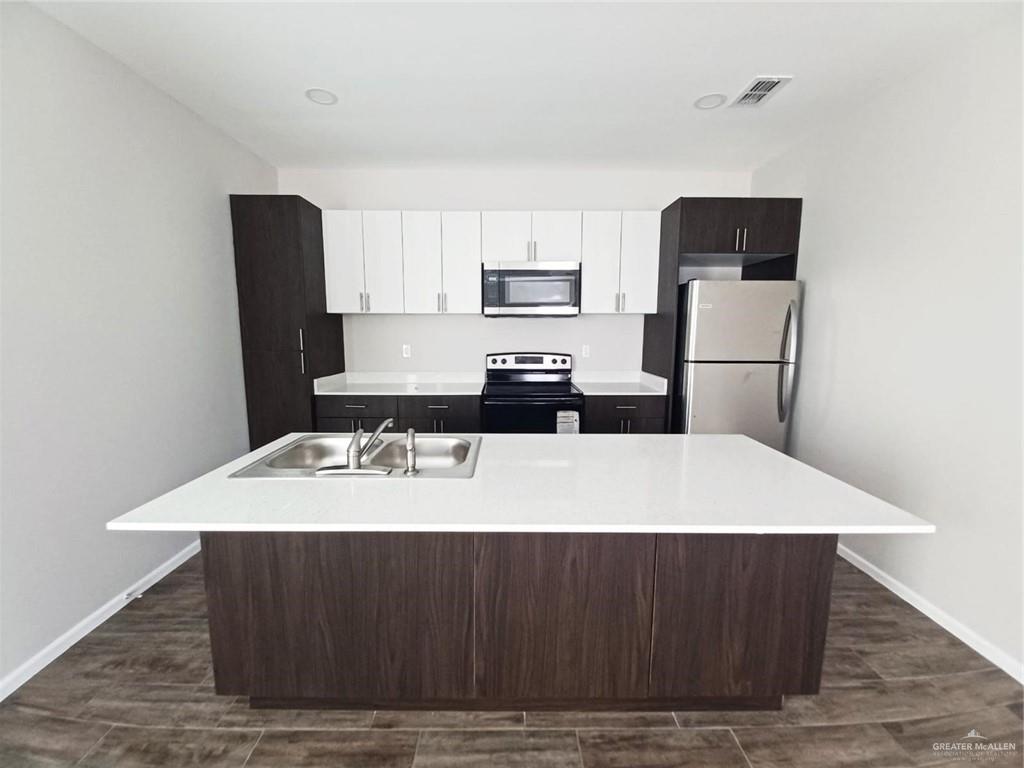 811 East Starr Road, Unit D Mercedes, TX 78570 - Photo 3 of 11 a kitchen with a wooden floor