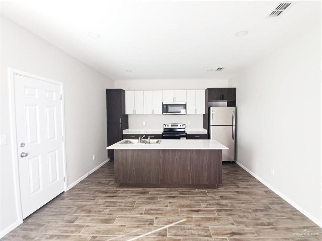 811 East Starr Road, Unit D Mercedes, TX 78570 - Photo 5 of 11 a view of kitchen with stainless steel appliances wooden floor and window
