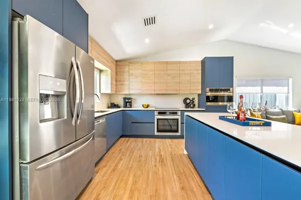 a large kitchen with stainless steel appliances granite countertop a refrigerator a sink dishwasher a stove with wooden floor and cabinets