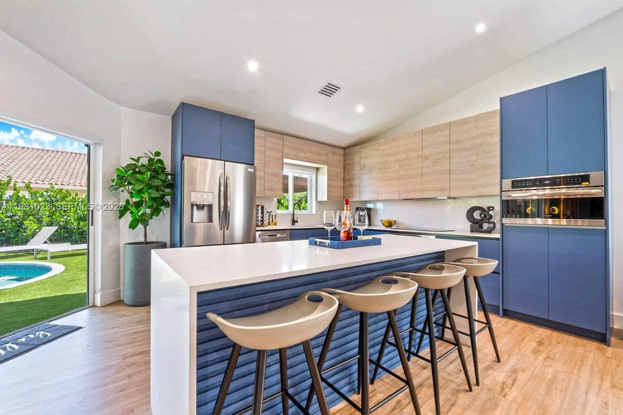 14481 Southwest 161 Street Miami, FL 33177 - Photo 14 of 24 a kitchen with stainless steel appliances a table and chairs in it