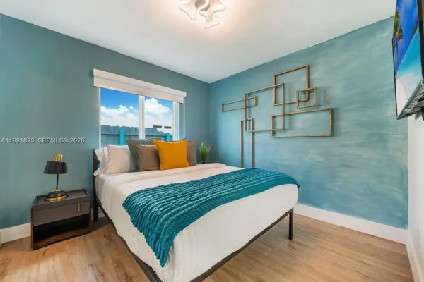 a bedroom with a bed and wooden floor