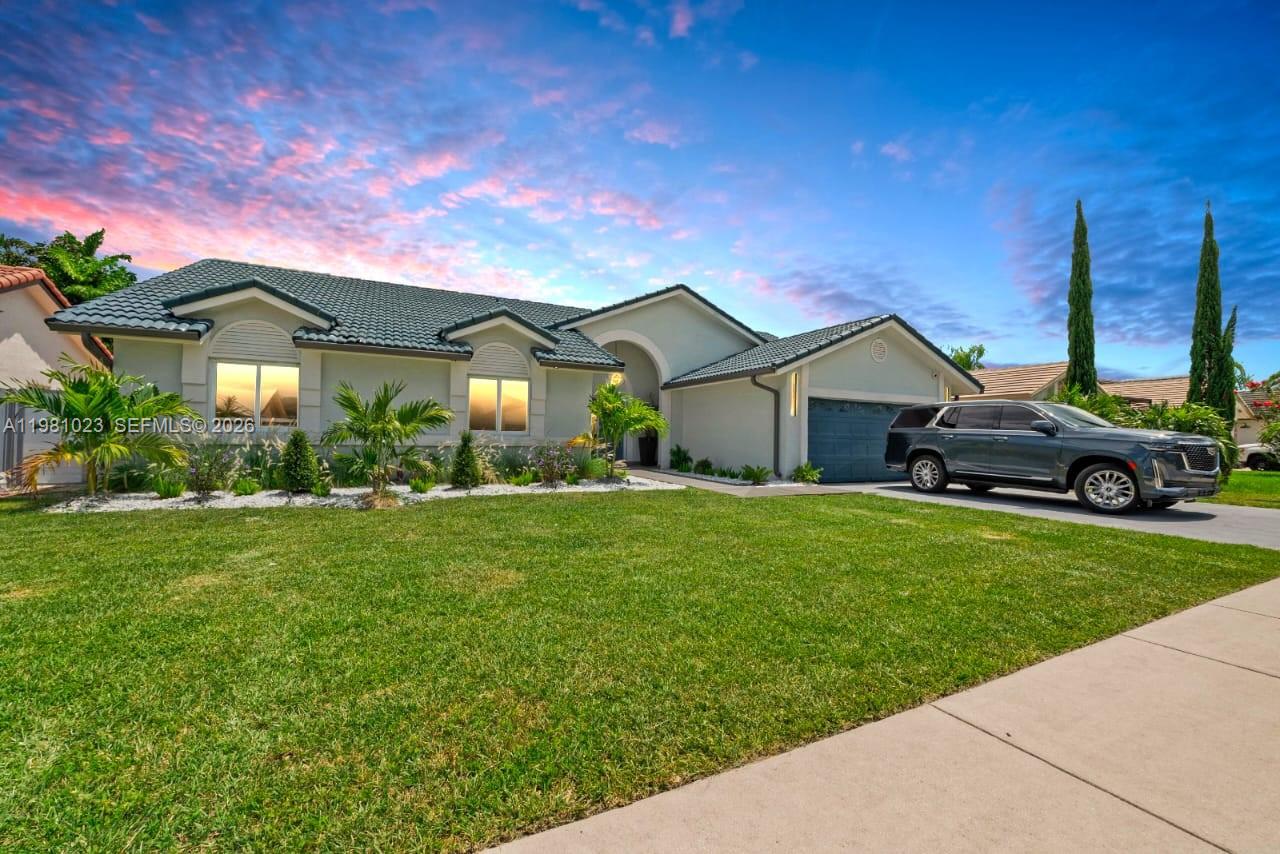 14481 Southwest 161 Street Miami, FL 33177 - Photo 2 of 24 a front view of a house with a garden