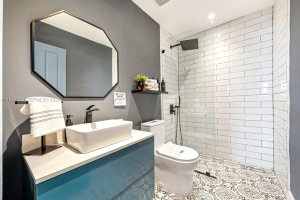 a bathroom with a sink mirror toilet and shower