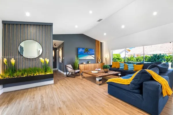 a living room with furniture fireplace and a large window