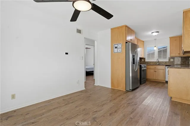 a kitchen with stainless steel appliances a refrigerator and wooden floor