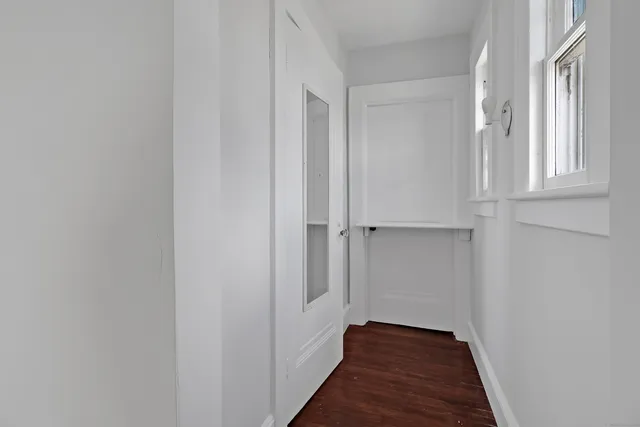 a view of a hallway with wooden floor and entryway