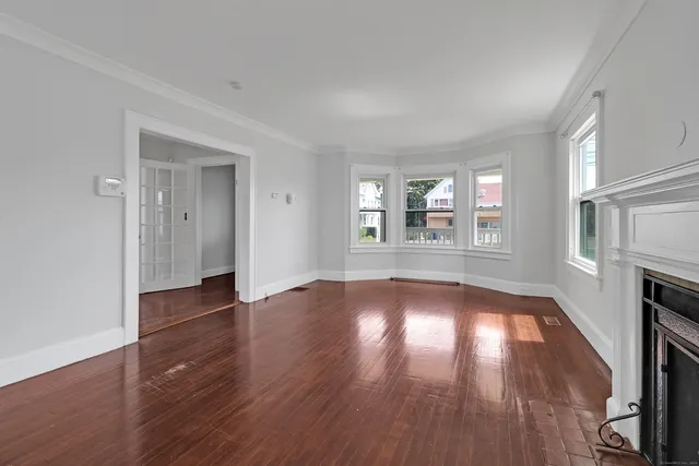 an empty room with wooden floor and fireplace