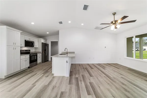 a view of kitchen with microwave oven stove and cabinets
