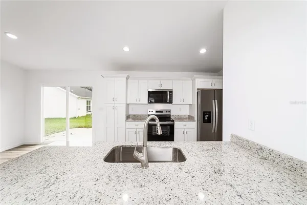 a kitchen with stainless steel appliances a sink a stove and a refrigerator