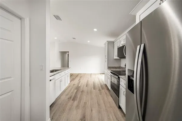 a kitchen with stainless steel appliances granite countertop a refrigerator and a stove top oven