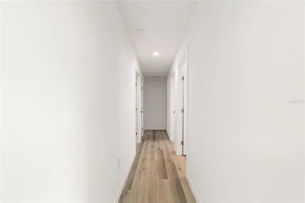 a view of a hallway with wooden floor