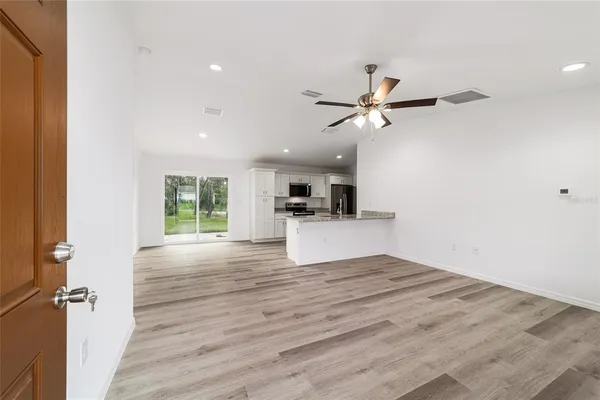 a view of empty room with wooden floor and a ceiling fan