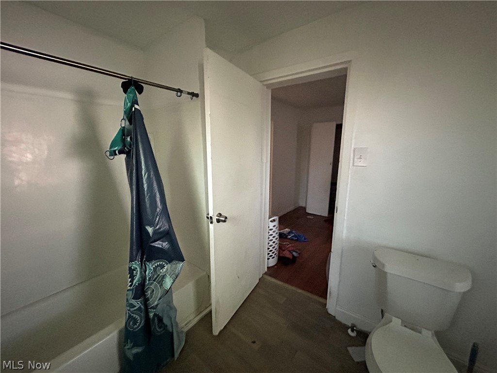 7723 Spafford Road Cleveland, OH 44105 - Photo 11 of 14 Bathroom featuring wood-type flooring, toilet, and shower / bath combination with curtain