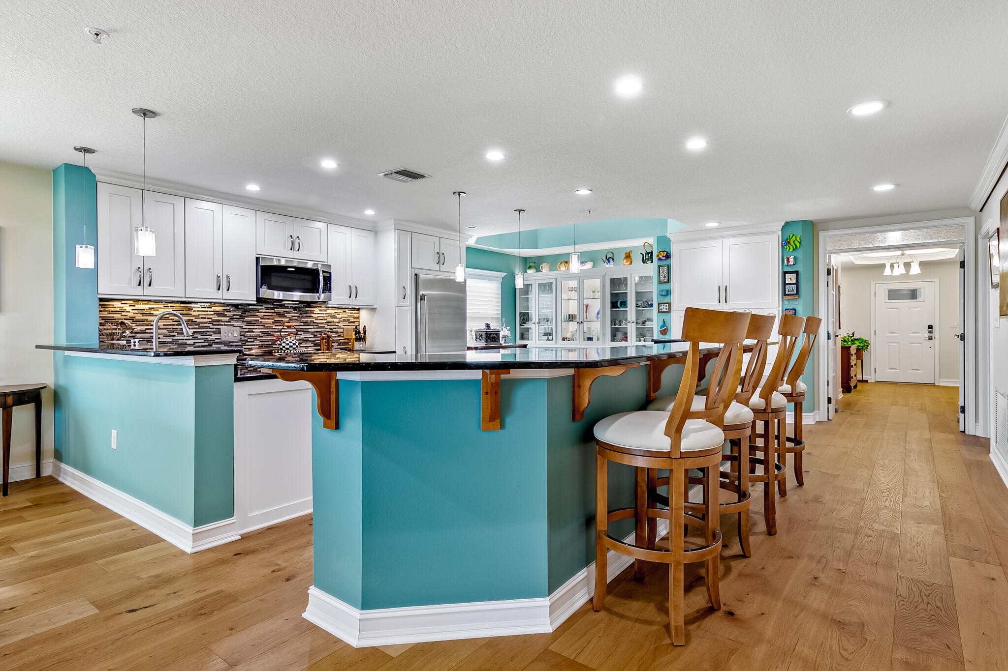 29 Riverside Drive, Unit 401 Cocoa, FL 32922 - Photo 24 of 41 a kitchen with stainless steel appliances granite countertop wooden floor a dining table chairs and a refrigerator