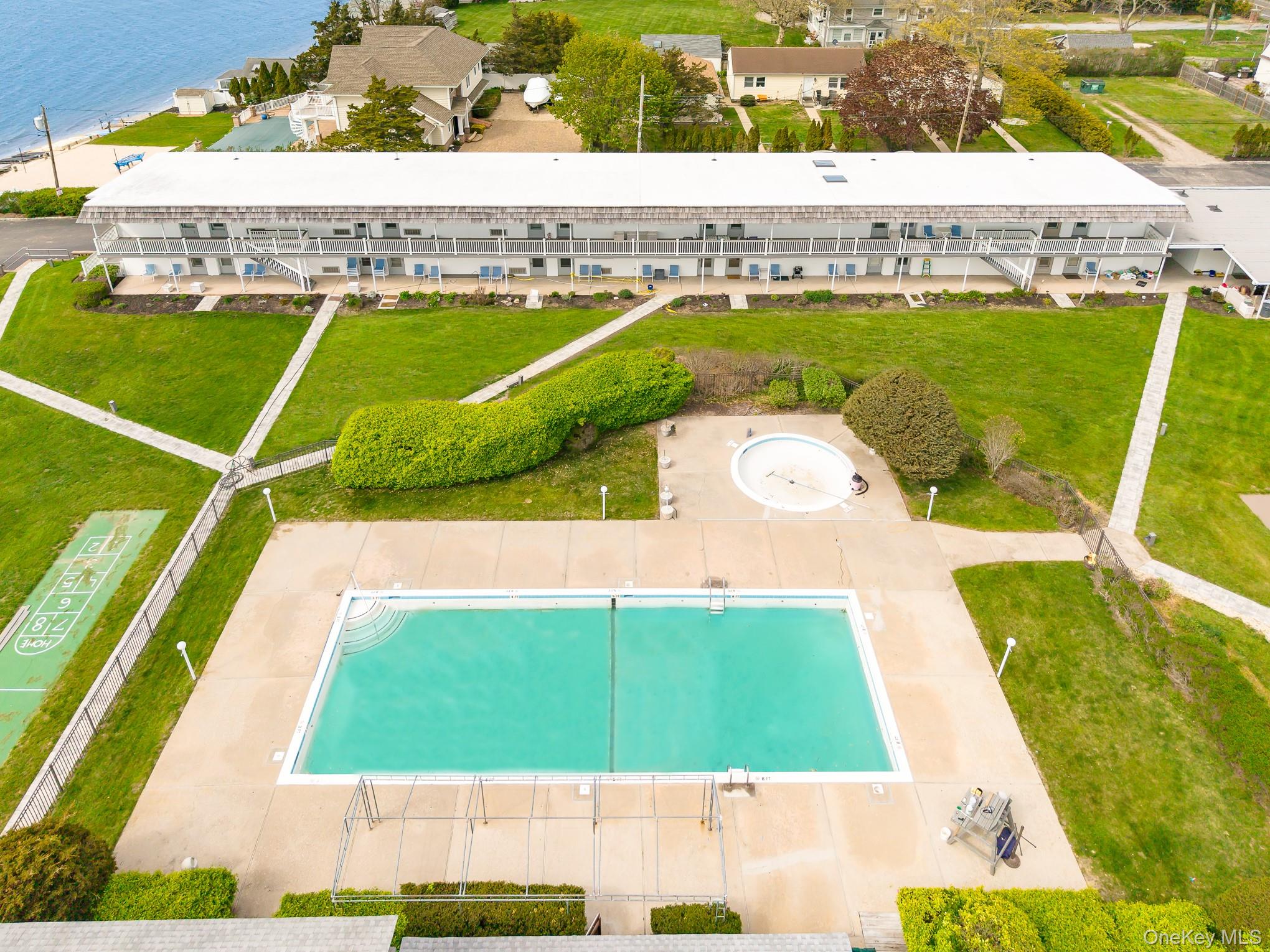 50 Rampasture Road, Unit 6 Hampton Bays, NY 11946 - Photo 14 of 35 a view of a swimming pool with a outdoor seating
