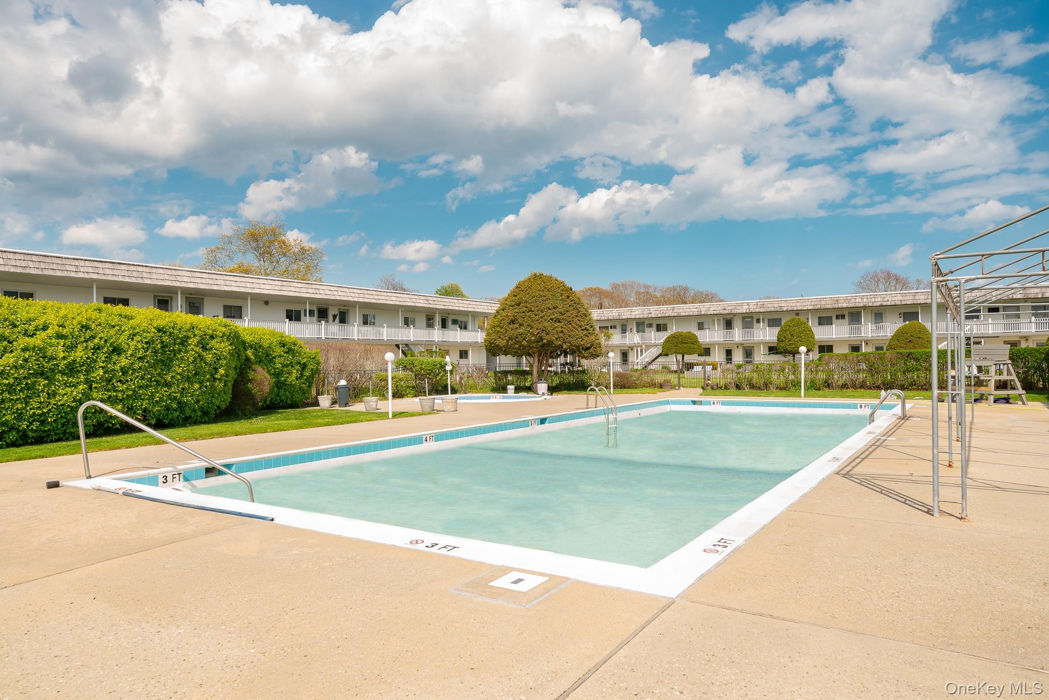 50 Rampasture Road, Unit 6 Hampton Bays, NY 11946 - Photo 19 of 35 a view of a swimming pool and an outdoor seating