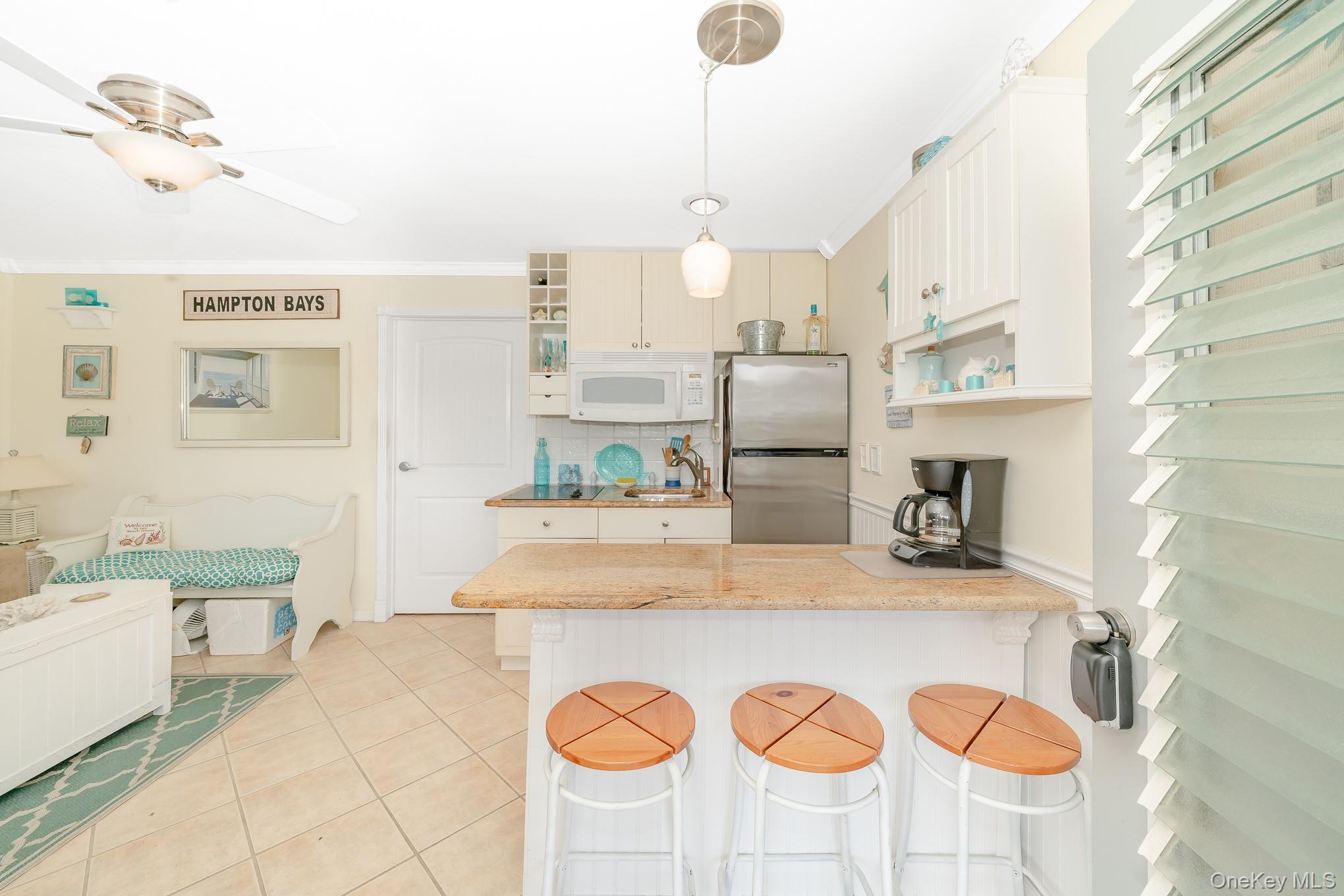 50 Rampasture Road, Unit 6 Hampton Bays, NY 11946 - Photo 23 of 35 a kitchen with kitchen island granite countertop a sink a stove and a refrigerator