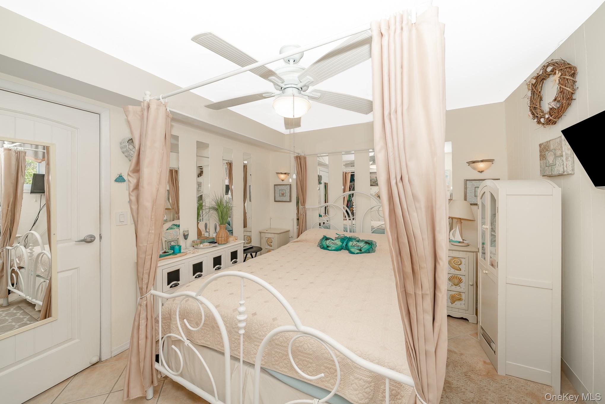 50 Rampasture Road, Unit 6 Hampton Bays, NY 11946 - Photo 29 of 35 a bedroom with a bed and a mirror