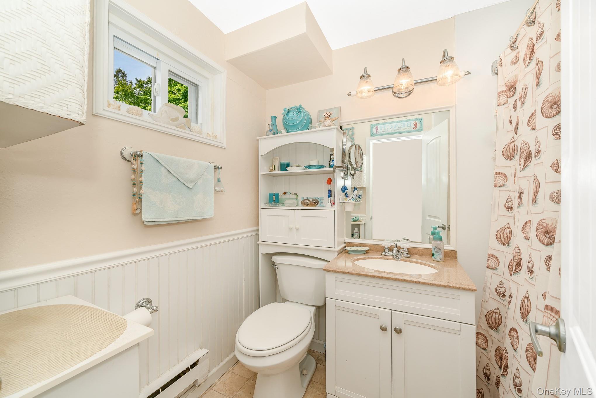 50 Rampasture Road, Unit 6 Hampton Bays, NY 11946 - Photo 31 of 35 a bathroom with a sink mirror vanity and toilet