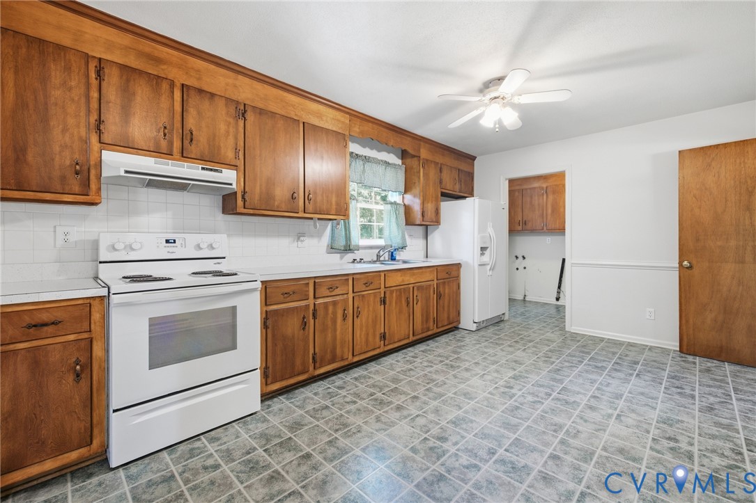Kitchen featuring wood-finish cabinetry, white app