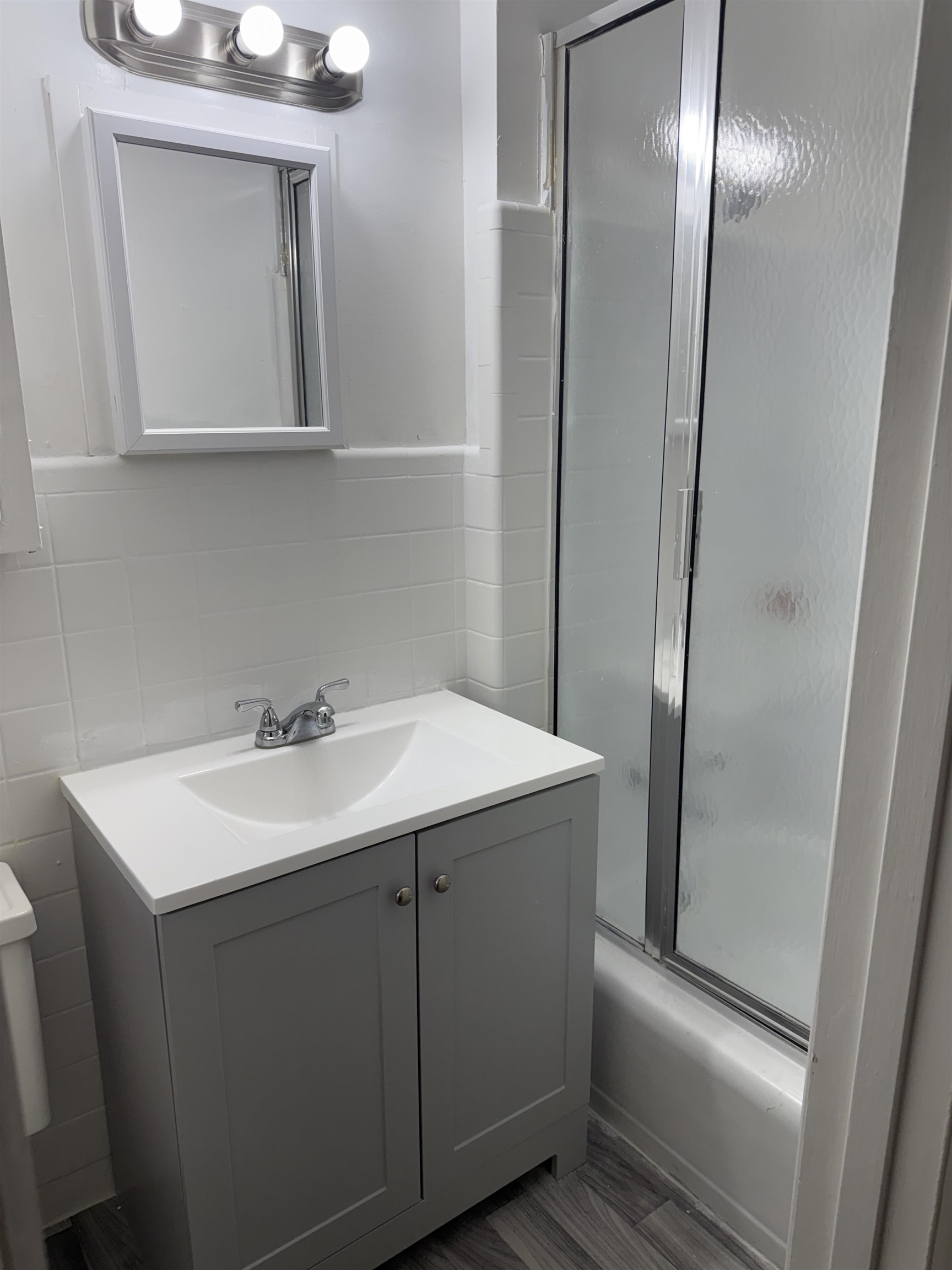 4089 Tessland Road Memphis, TN 38128 - Photo 25 of 34 Bathroom featuring vanity, shower / bath combination with glass door, tasteful backsplash, and tile walls