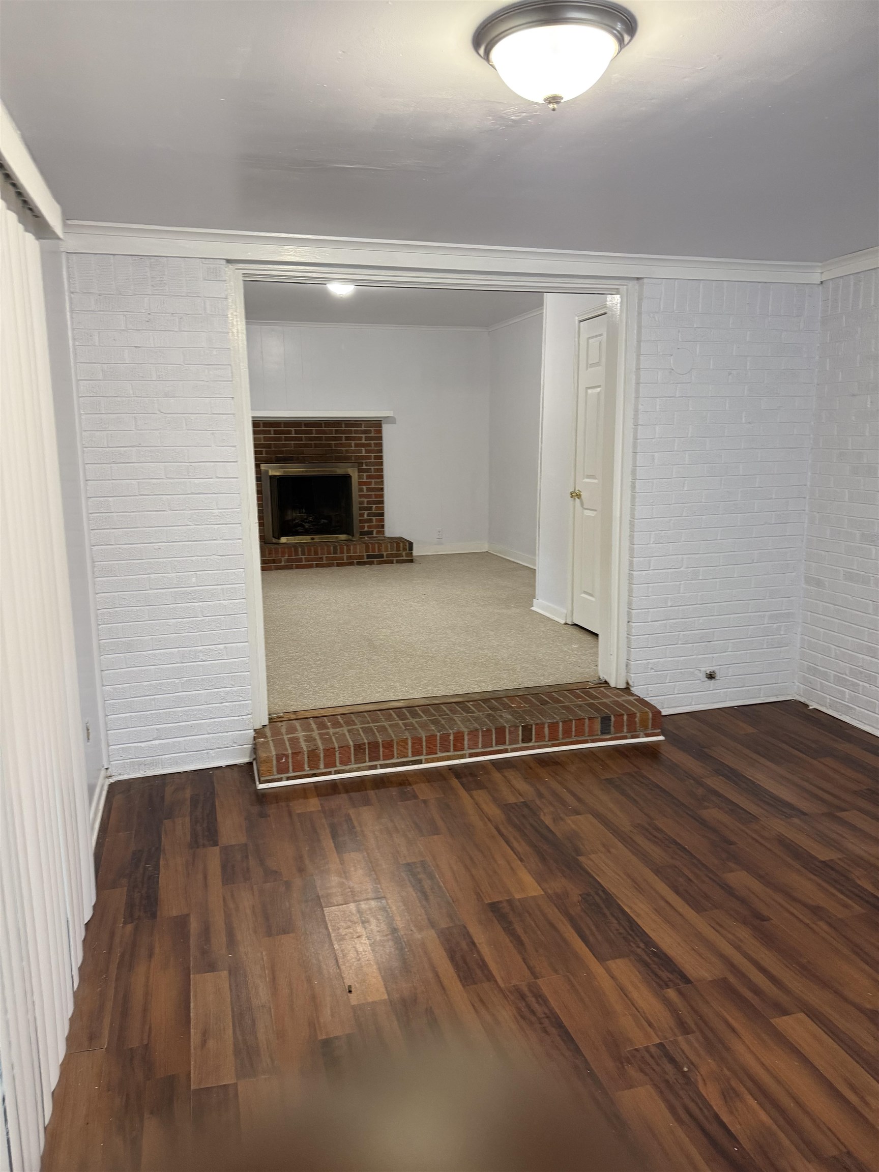 4089 Tessland Road Memphis, TN 38128 - Photo 28 of 34 Basement with brick wall, wood finished floors, and a brick fireplace