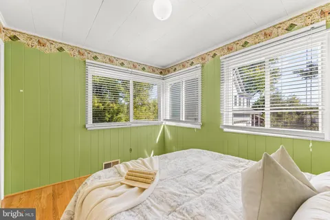 a bedroom with a bed and windows